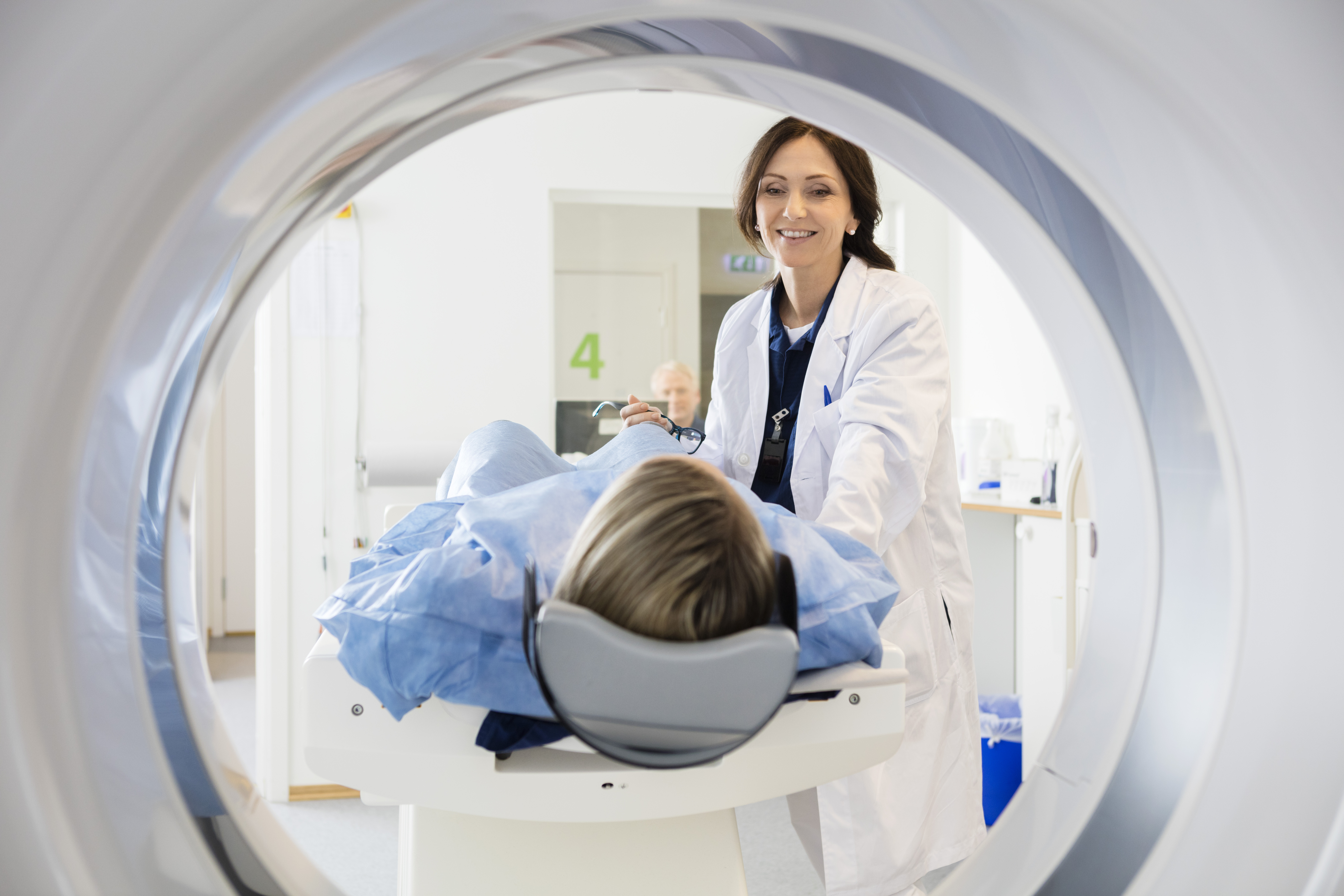 Imaging tech specialist preparing patient for MRI