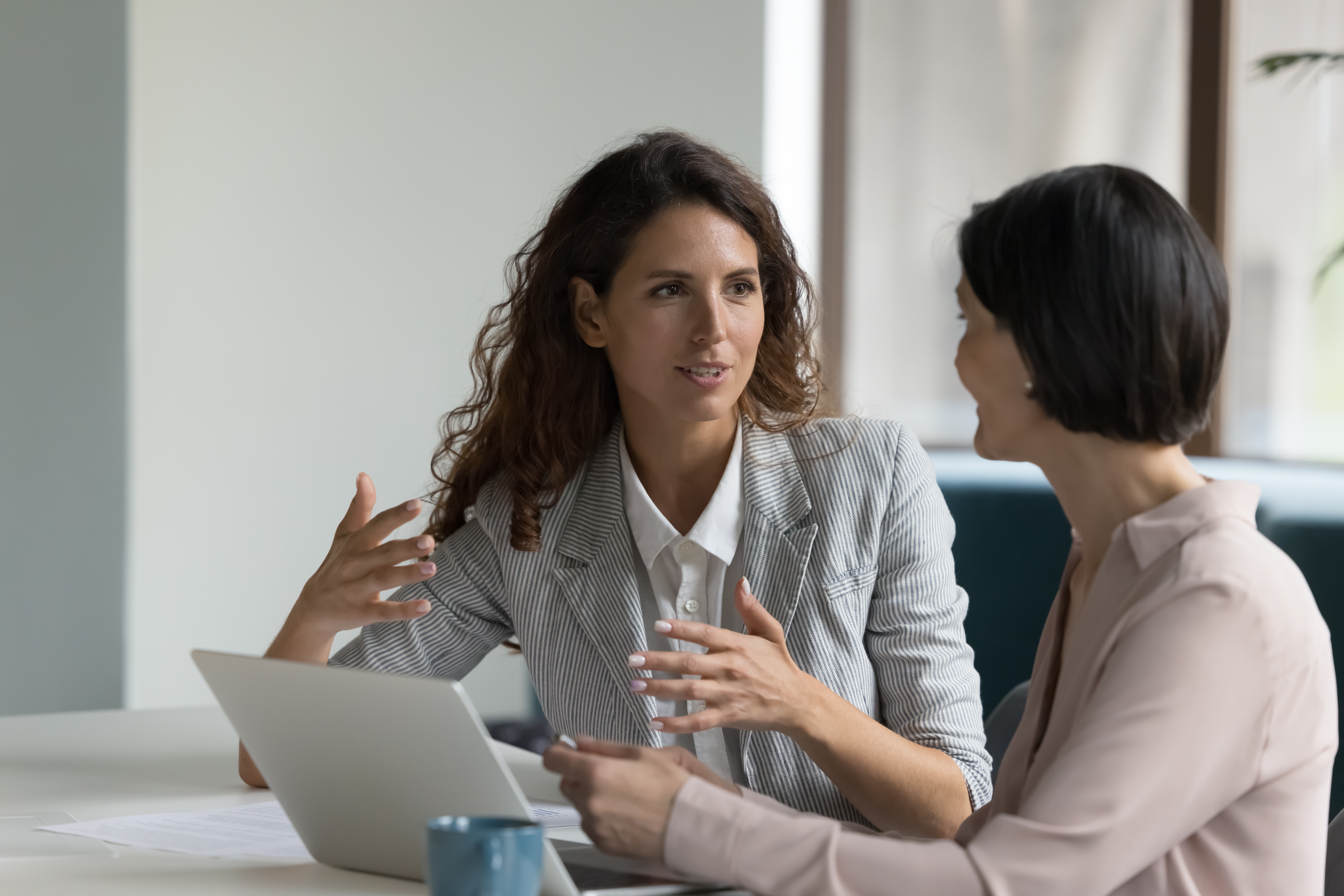 Allied Health Staffing Solutions with TRS Managed Services Two businesswomen sitting at a desk with a laptop in discussion