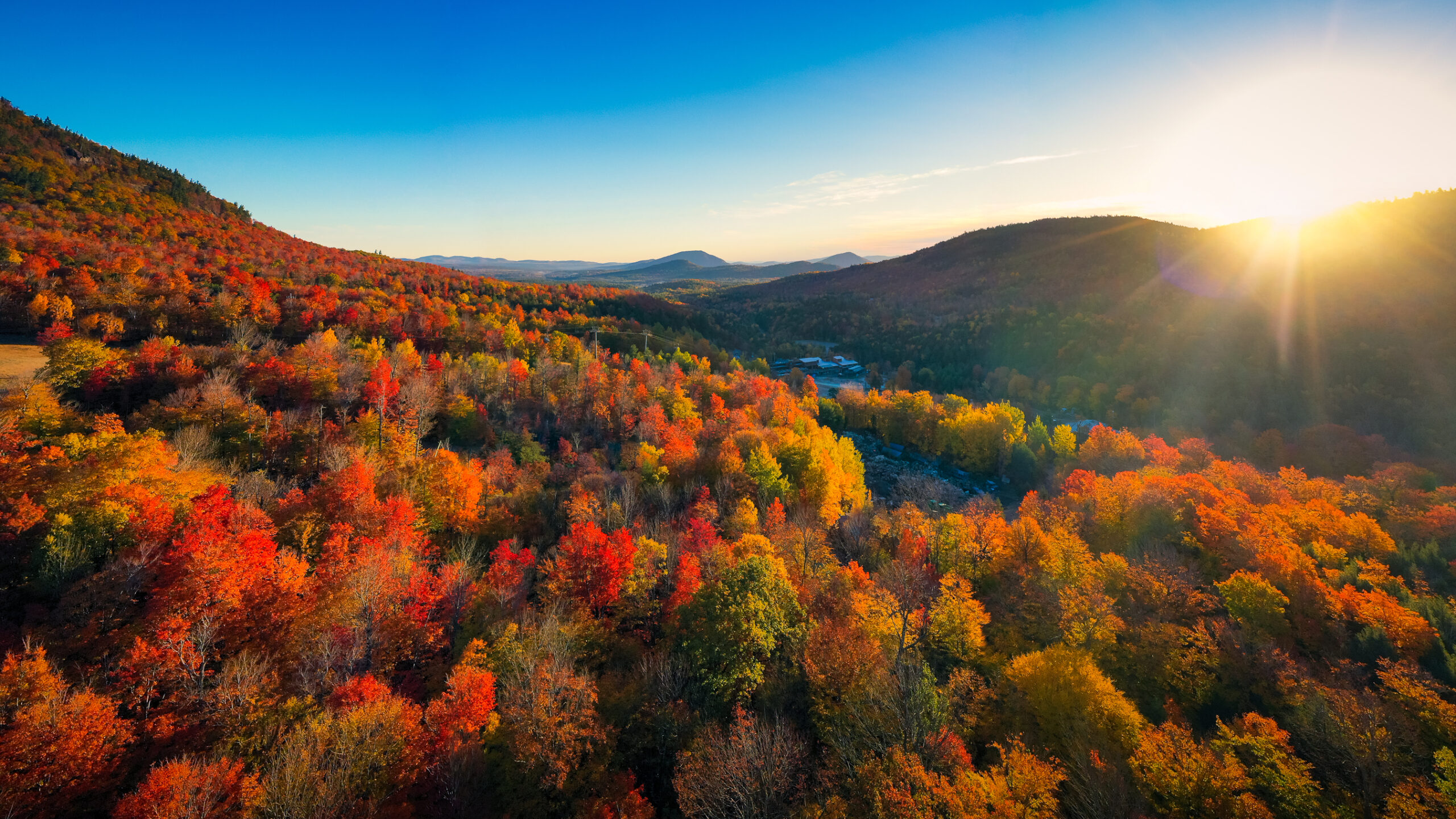 Travel Healthcare Jobs in New York Aerial view of Mountain Forests with Brilliant Fall Colors in Autumn at Sunrise, Adirondacks, New York, New England