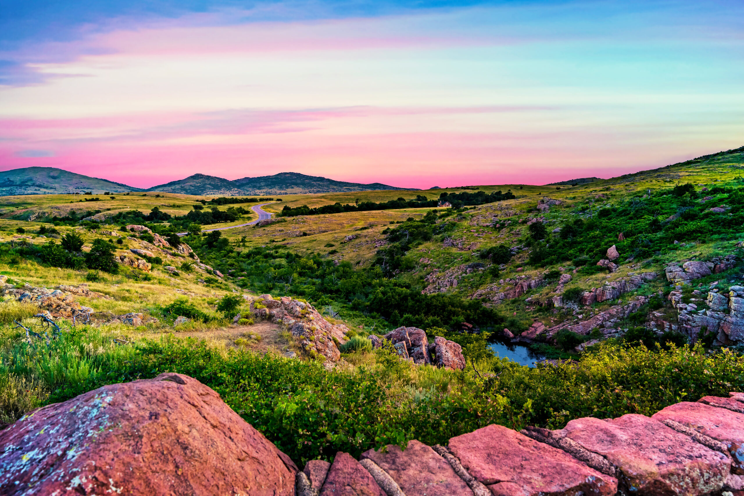 Travel Healthcare Jobs in Oklahoma The beautiful green vibrant hills glowing in the sunset under a pastel colored sky at Wichita Mountains Wildlife Refuge near Lawton, Oklahoma, USA
