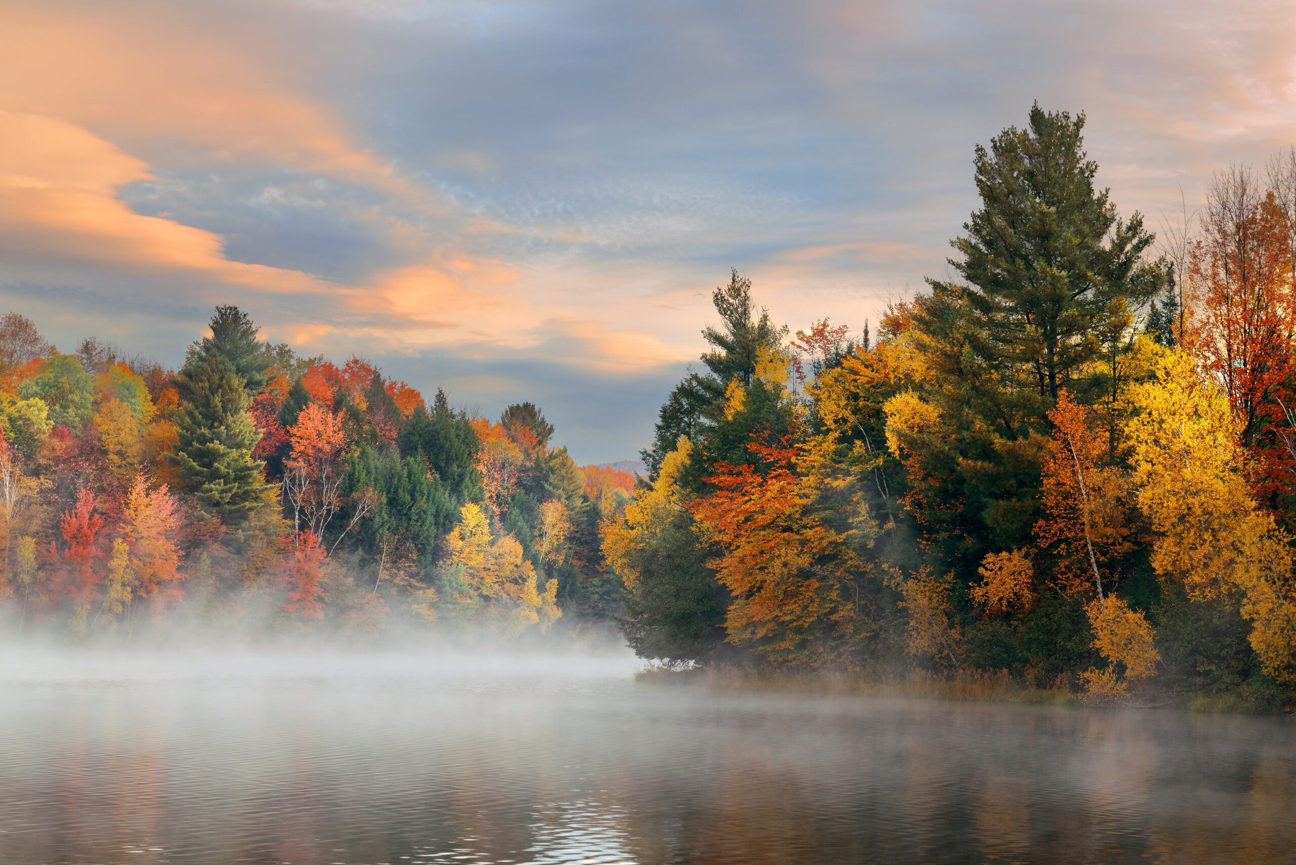 Lake fog sunrise with Autumn foliage and mountains in New England Stowe