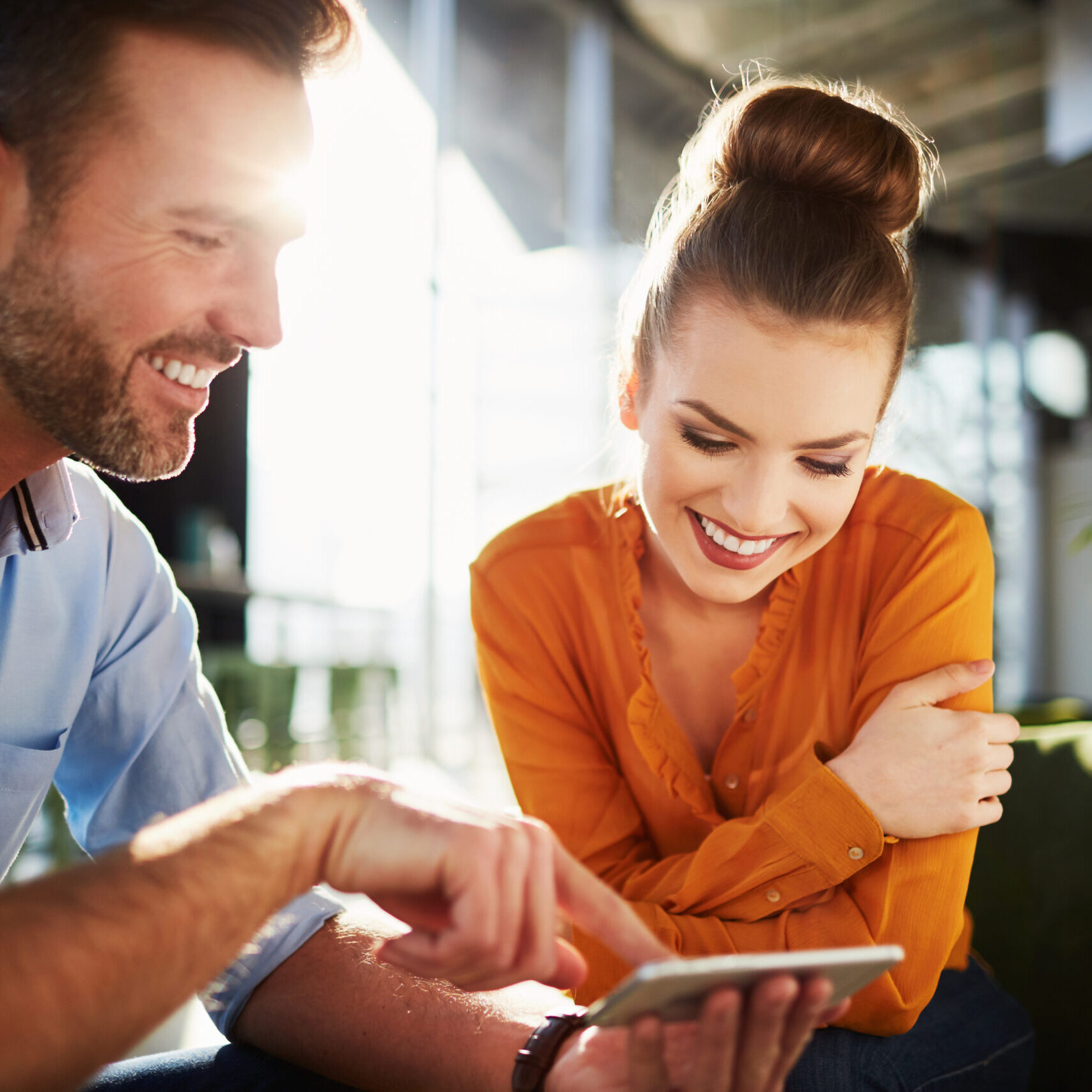 Recruiting Team Young couple in modern cafe looking at smartphone